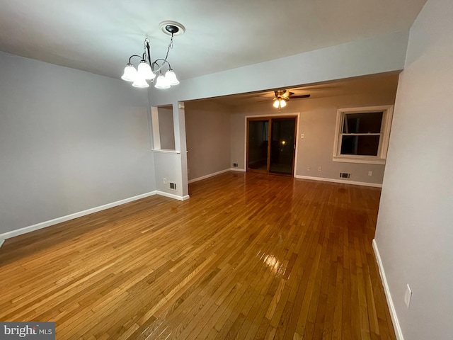 unfurnished room with hardwood / wood-style flooring and ceiling fan with notable chandelier