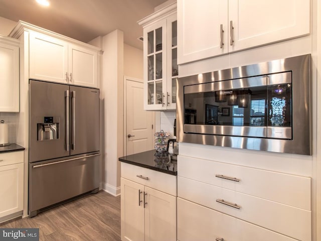 kitchen featuring tasteful backsplash, white cabinetry, appliances with stainless steel finishes, and light hardwood / wood-style flooring