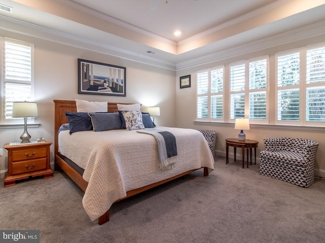 carpeted bedroom with multiple windows, crown molding, and a tray ceiling