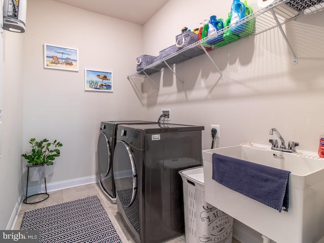 laundry room with sink, light tile patterned floors, and washer and clothes dryer