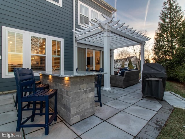 patio terrace at dusk featuring a bar, a grill, and a pergola