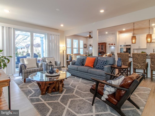 living room with light hardwood / wood-style flooring and ceiling fan