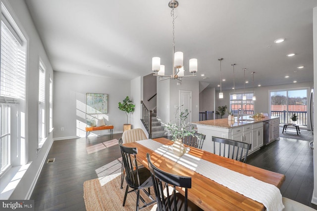 dining space with dark hardwood / wood-style flooring, sink, and a notable chandelier