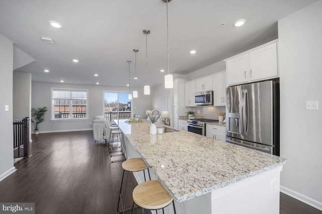 kitchen featuring white cabinetry, appliances with stainless steel finishes, a large island, and sink