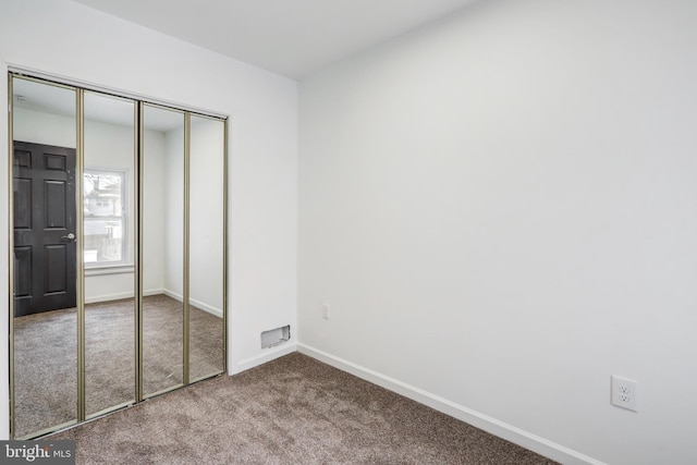 unfurnished bedroom featuring carpet flooring and a closet