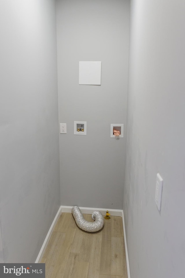 clothes washing area with washer hookup, laundry area, light wood-style floors, and baseboards