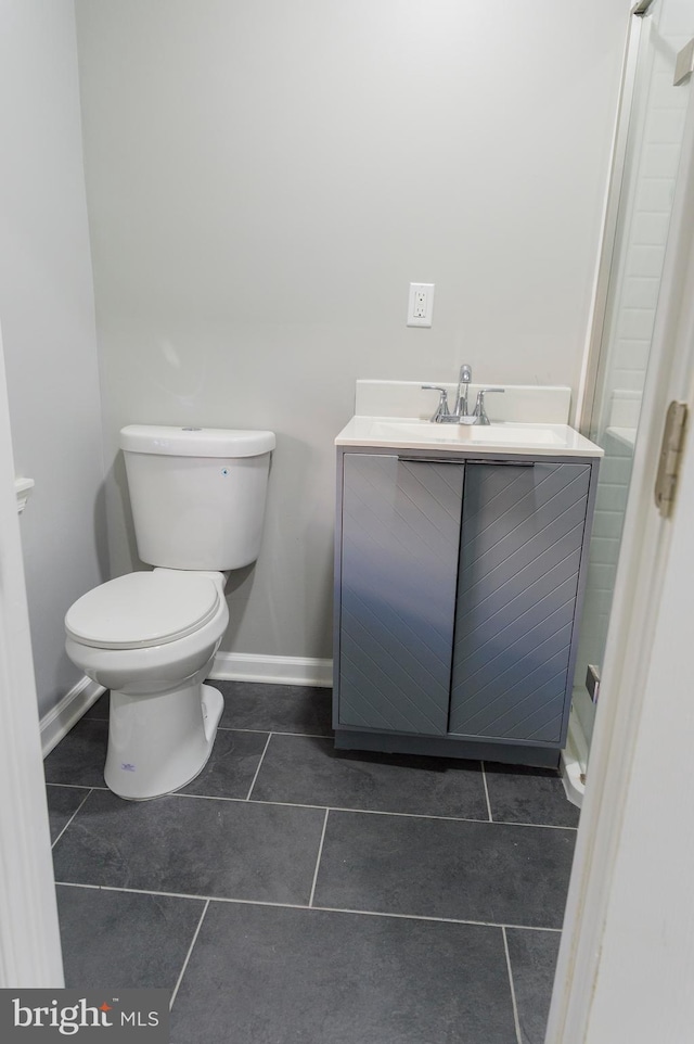 bathroom featuring tile patterned flooring, toilet, vanity, and baseboards