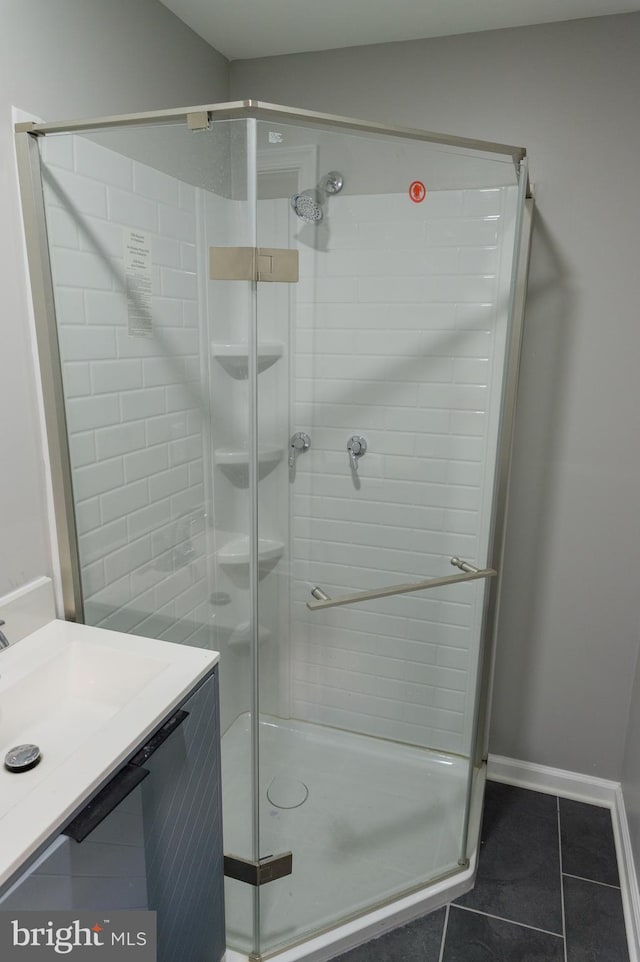 bathroom featuring tile patterned flooring, a stall shower, and vanity