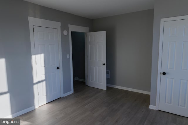 unfurnished bedroom with wood finished floors and baseboards