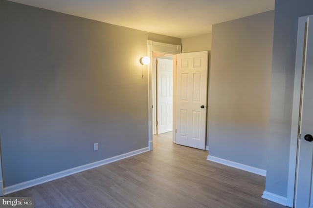 interior space featuring baseboards and wood finished floors