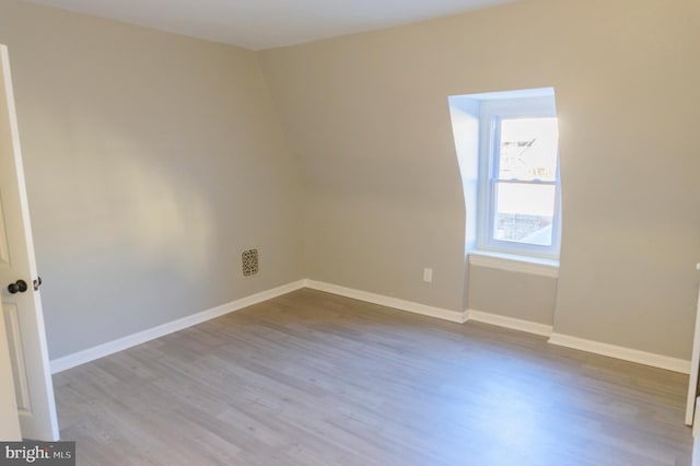 empty room with baseboards and wood finished floors