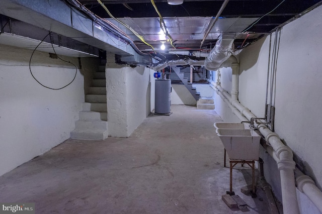 unfinished below grade area with gas water heater, stairs, and a sink