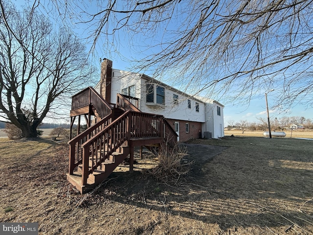 back of house featuring a wooden deck and central AC