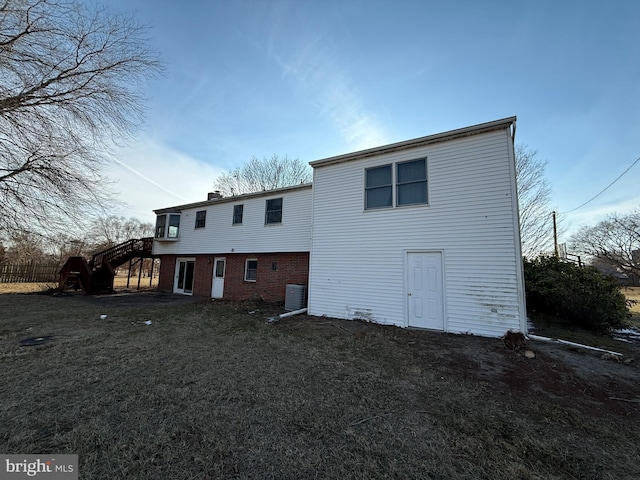 back of house with a lawn and central air condition unit