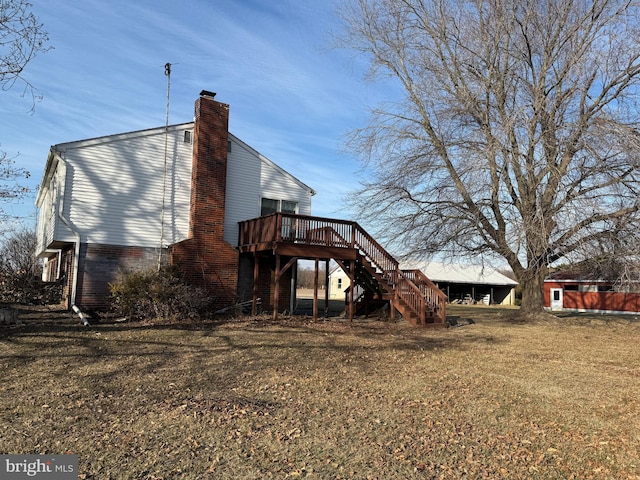 back of house with a wooden deck and a yard