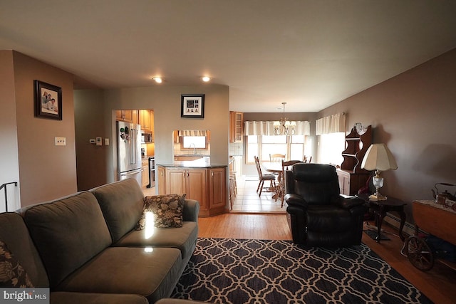 living room with a notable chandelier and light wood-type flooring