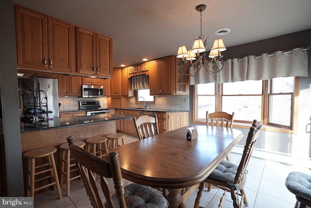 tiled dining area with an inviting chandelier and sink