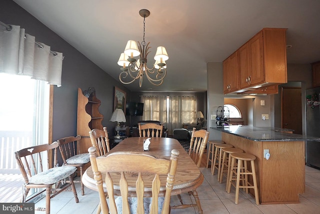 dining room with a wealth of natural light, light tile patterned floors, and a chandelier