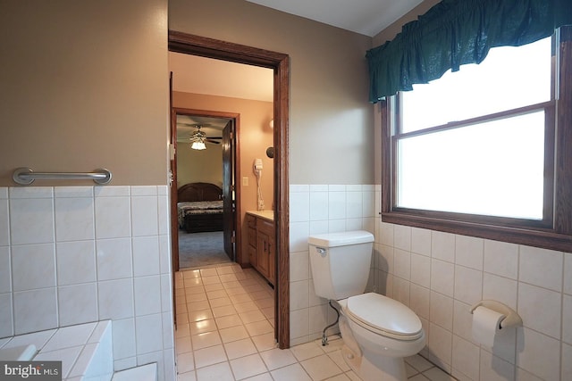 bathroom with vanity, tile walls, tile patterned floors, and toilet