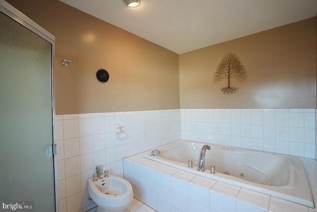 bathroom with a bidet, tile walls, and separate shower and tub