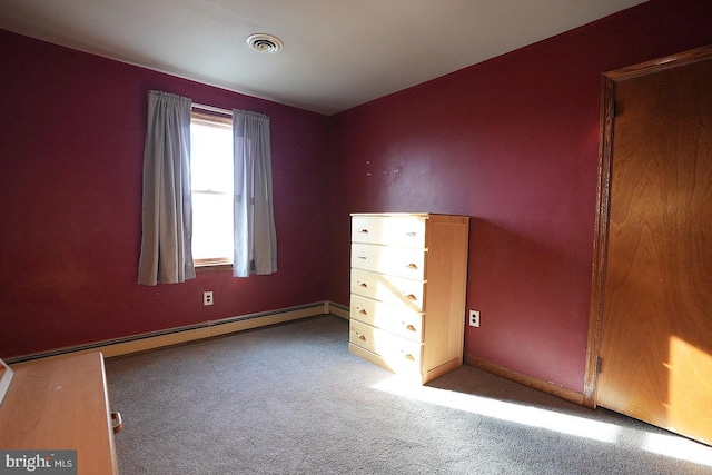 unfurnished bedroom with a baseboard heating unit and carpet floors