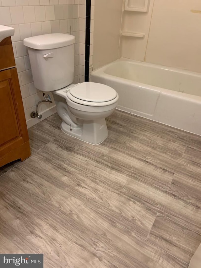 full bathroom with vanity, bathtub / shower combination, hardwood / wood-style floors, and toilet