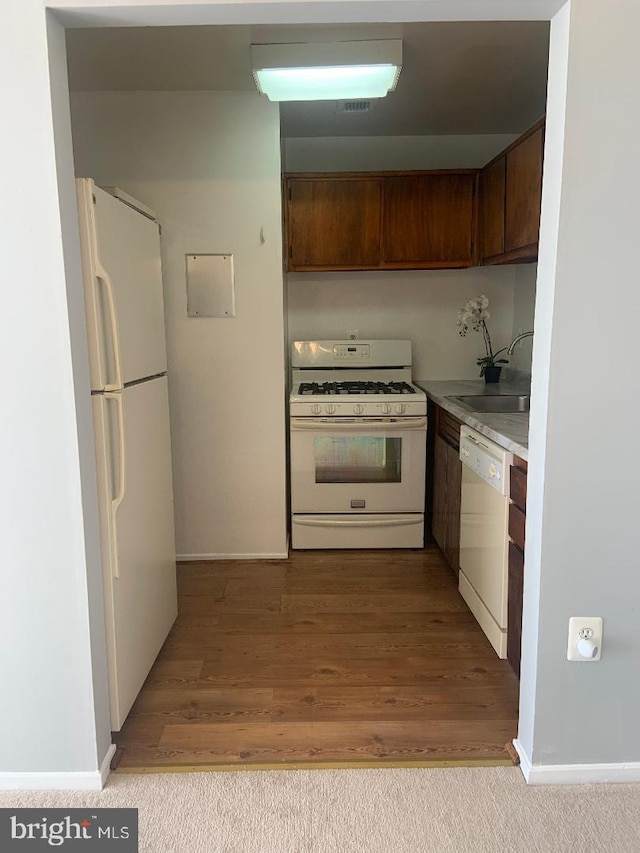 kitchen with sink, white appliances, and light wood-type flooring