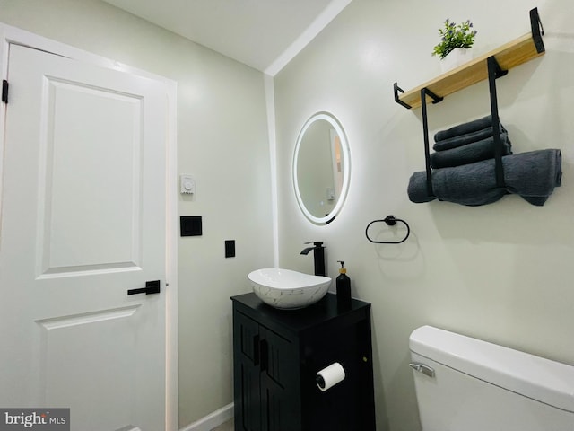 bathroom featuring vanity, toilet, and vaulted ceiling