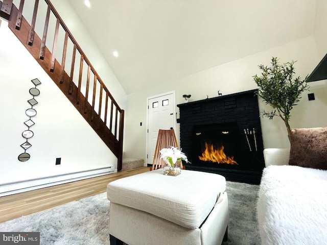 living room featuring a brick fireplace, wood-type flooring, high vaulted ceiling, and a baseboard radiator