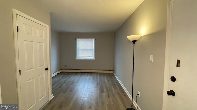 unfurnished room featuring a baseboard radiator and dark hardwood / wood-style floors