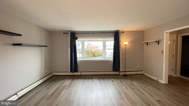 empty room featuring a baseboard radiator and wood-type flooring