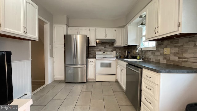 kitchen featuring sink, appliances with stainless steel finishes, white cabinets, decorative backsplash, and a baseboard heating unit