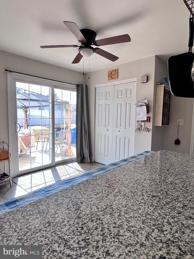 unfurnished bedroom featuring ceiling fan, a closet, and access to outside