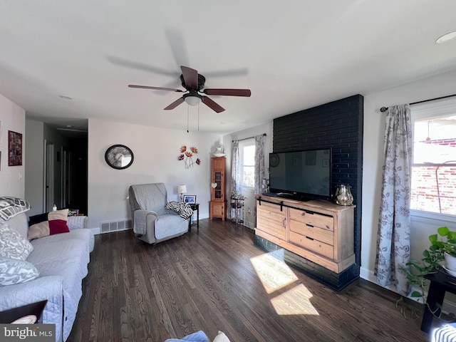 living room with ceiling fan, plenty of natural light, and dark hardwood / wood-style flooring