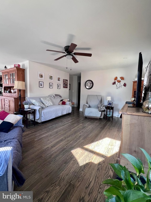 living room featuring ceiling fan and dark hardwood / wood-style flooring