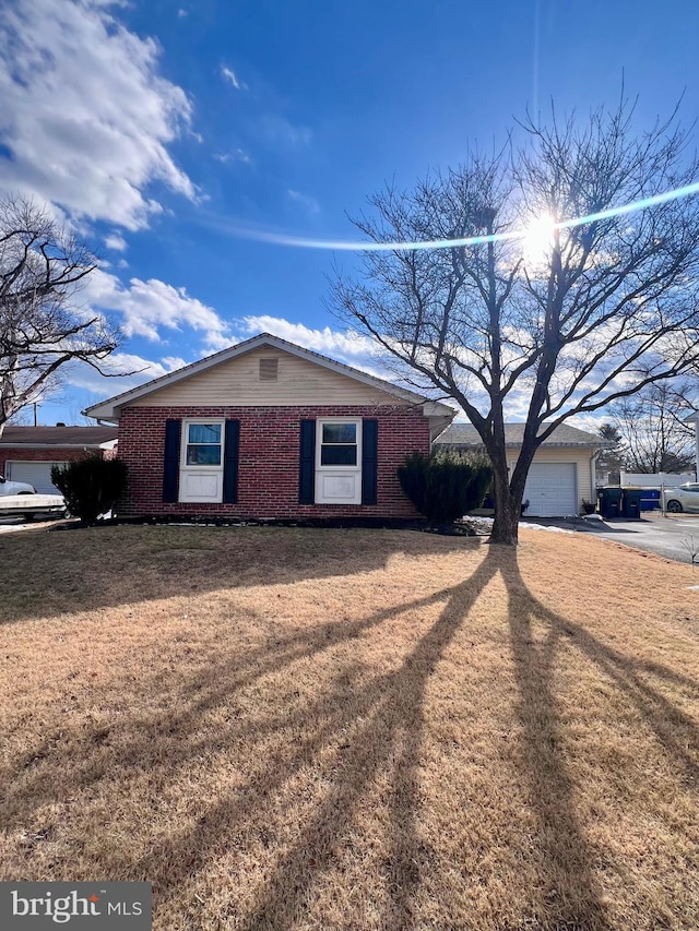 single story home with a garage and a front lawn