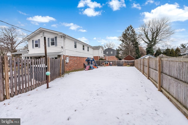 yard covered in snow with a playground