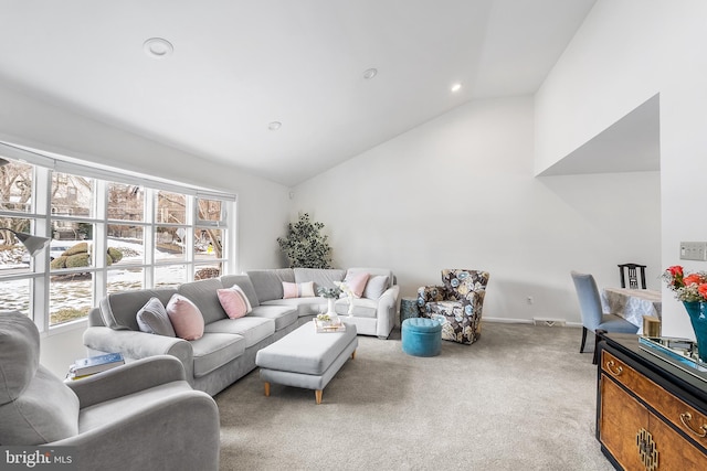 living room with high vaulted ceiling and light carpet