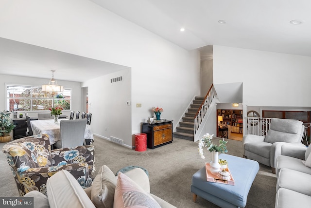 carpeted living room with high vaulted ceiling