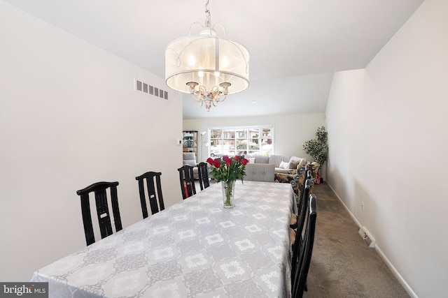 carpeted dining room featuring a notable chandelier