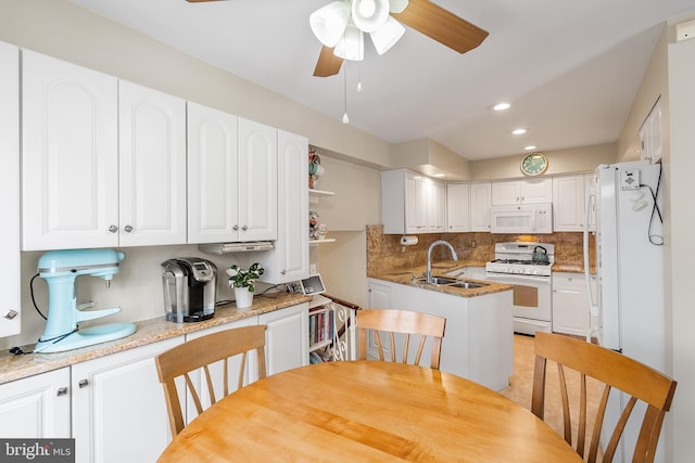 kitchen with white cabinetry, sink, white appliances, and light stone countertops