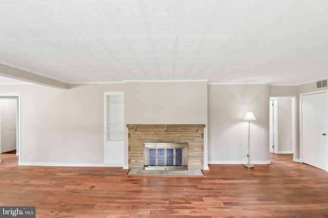 unfurnished living room featuring a fireplace with flush hearth, wood finished floors, baseboards, and crown molding