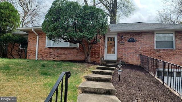 view of front facade featuring a front lawn, brick siding, fence, and a shingled roof