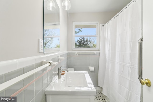 full bathroom with tile walls, vanity, and a shower with curtain