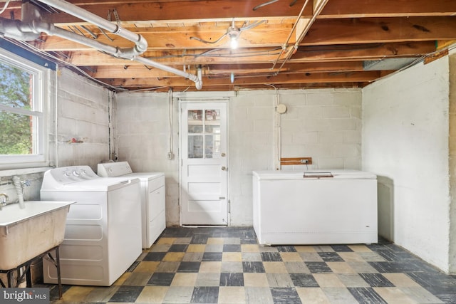 clothes washing area featuring a sink, tile patterned floors, laundry area, and independent washer and dryer
