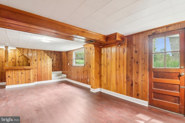 basement featuring stairway, baseboards, wood finished floors, and wooden walls
