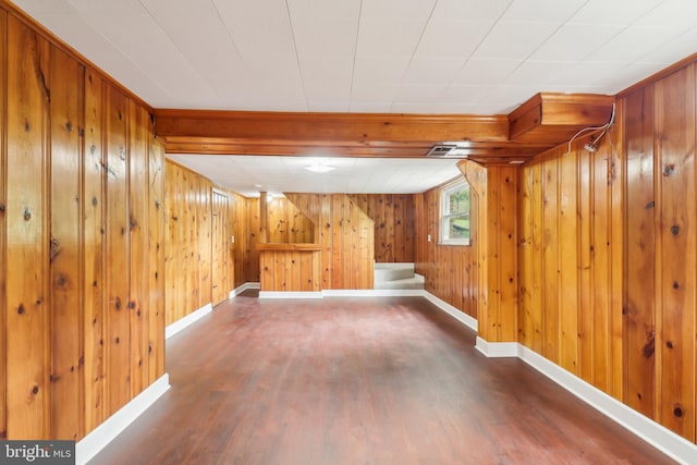 basement featuring wooden walls, wood finished floors, and baseboards