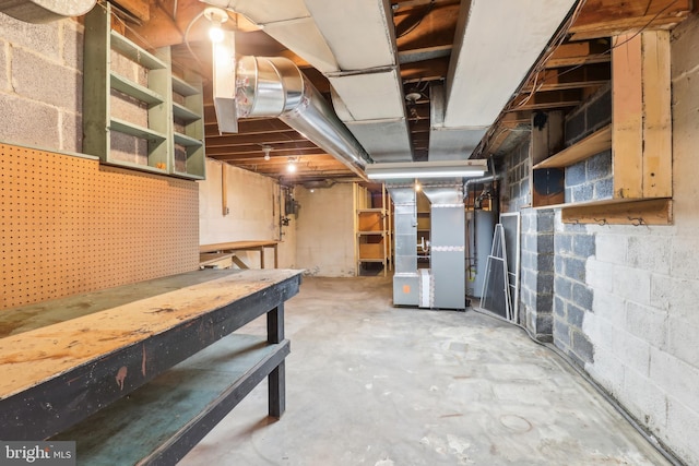 unfinished basement with a workshop area and heating unit
