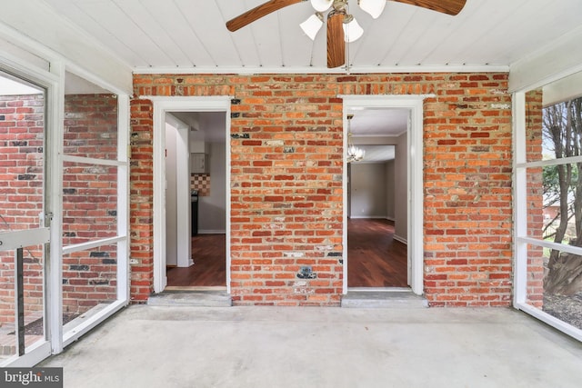 unfurnished sunroom featuring a ceiling fan