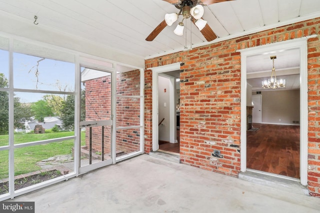 unfurnished sunroom featuring ceiling fan with notable chandelier
